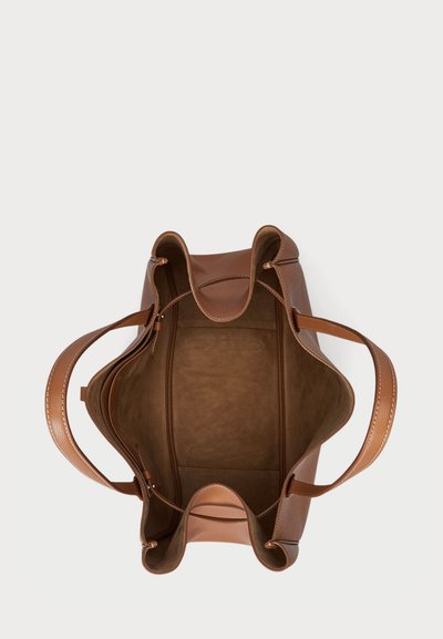 Brun læder tote taske med åben top, buede sider og to robuste håndtag. Indersiden er i suedesvillignende materiale med en glat tekstur.