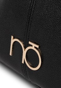 Zwarte, gestructureerde leren handtas met een goudkleurig logo-accent. Het ontwerp bevat zichtbare stiksels en heeft een gladde, gestructureerde vorm.