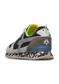 Sneaker grigio e nero con una tomaia in suede e mesh, foderata in verde e suola in gomma con motivo per una migliore trazione. Presenta un logo distintivo sul retro.