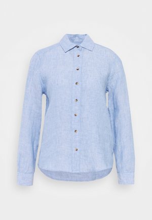 Chemise en lin bleu clair à manches longues avec un col et des boutons marron sur le devant, présentée sur un fond blanc.