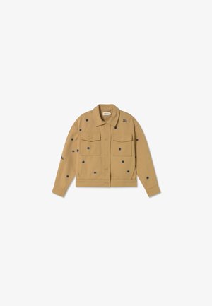Tan denim jacket met twee voorzakken, versierd met marineblauwe bloemenborduring en het woord "SOL" bij de kraag, met knoopsluiting aan de voorkant.