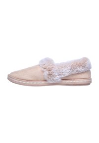 Beige suède slippers met een nepbont kraag, lage profiel, ronde neus en gestikte details langs de rand. Zachte textuur overal.