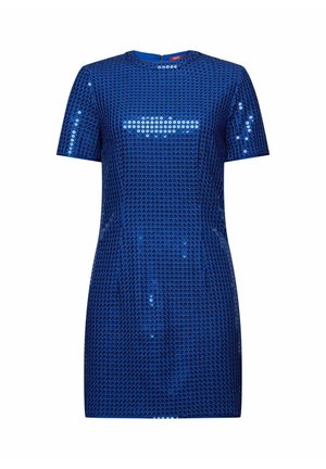 Vrouw draagt een koningsblauwe paillettenjurk met korte mouwen, een ronde halslijn en een gestructureerd patroon, die boven de knie valt.