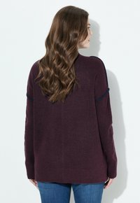 Maglione a maglia bordeaux con maniche lunghe, design leggermente sceso sulle spalle, orlo a coste e accenti a contrasto in blu navy sulle spalle. Vestibilità casual.