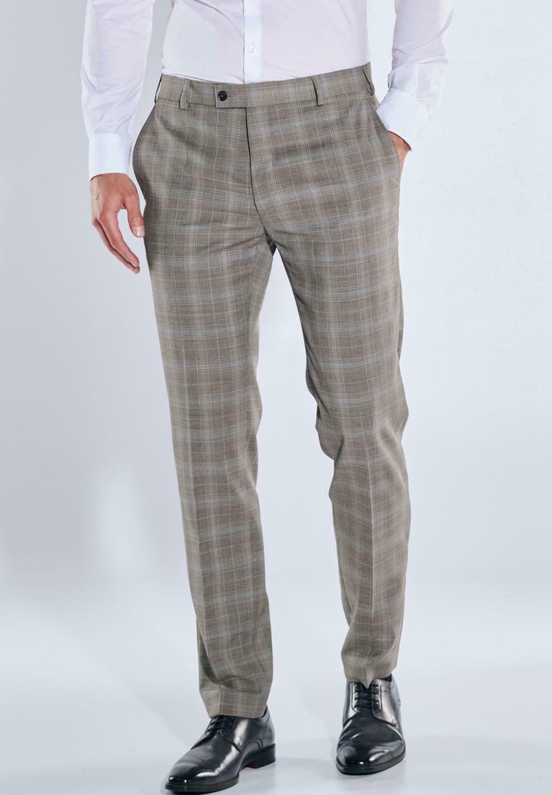Beige karierte Hose mit maßgeschneiderter Passform, flacher Vorderseite, Seitentaschen und passenden Gürtelschlaufen, kombiniert mit schwarzen Anzugschuhen.