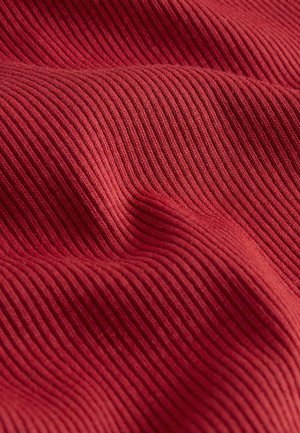 Textured fabric in a rich red hue, featuring narrow vertical ribbing. The material appears soft and stretchable with a smooth finish.