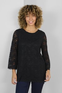 Black lace tunic with three-quarter bell sleeves, featuring a scalloped hem and textured pattern. Worn over dark jeans.