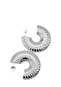 Orecchini a spirale in argento con texture rigata, design circolare aperto e chiusura con perno. La finitura riflettente esalta i dettagli visivi.