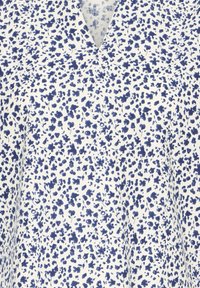 Tissu blanc avec un motif dense de petites fleurs et feuilles bleu marine, présentant un col en V.