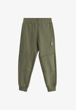 Pantalon de survêtement vert en tissu doux, avec poches latérales, panneau texturé sur le bas des jambes et ceinture élastique.