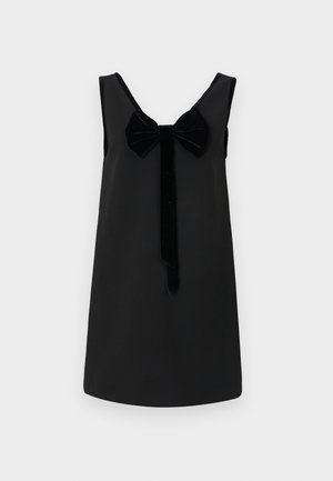 Une robe noire sans manches présente un décolleté rond, un accent en velours en forme de nœud à l'avant, et une silhouette droite avec une texture lisse.