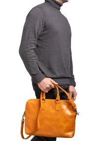 Borsa a mano in pelle marrone chiaro con doppi manici superiori e una tracolla regolabile. Texture liscia e forma rettangolare con chiusura a zip.