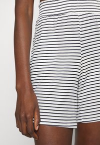 Gestreepte shorts met een smock tailleband in een witte stof met marineblauwe horizontale strepen, met een zachte textuur en een ontspannen pasvorm.