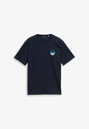 Tumši zila T-krekls ar īsām piedurknēm, apaļu izgriezumu un nelielu zilu aplīšu grafiku kreisajā krūtīs ar uzrakstu "Creative Atelier".