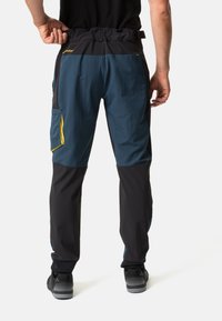 Pantalons d'extérieur pour hommes présentant un schéma de couleurs bleu et noir, une taille élastique, plusieurs poches et des coutures renforcées pour plus de durabilité.