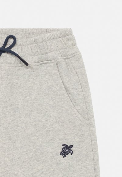 Lys grå joggebukser med elastisk midjebånd, svart snor, sidelomme og liten brodert svart skilpadde nær lommen.