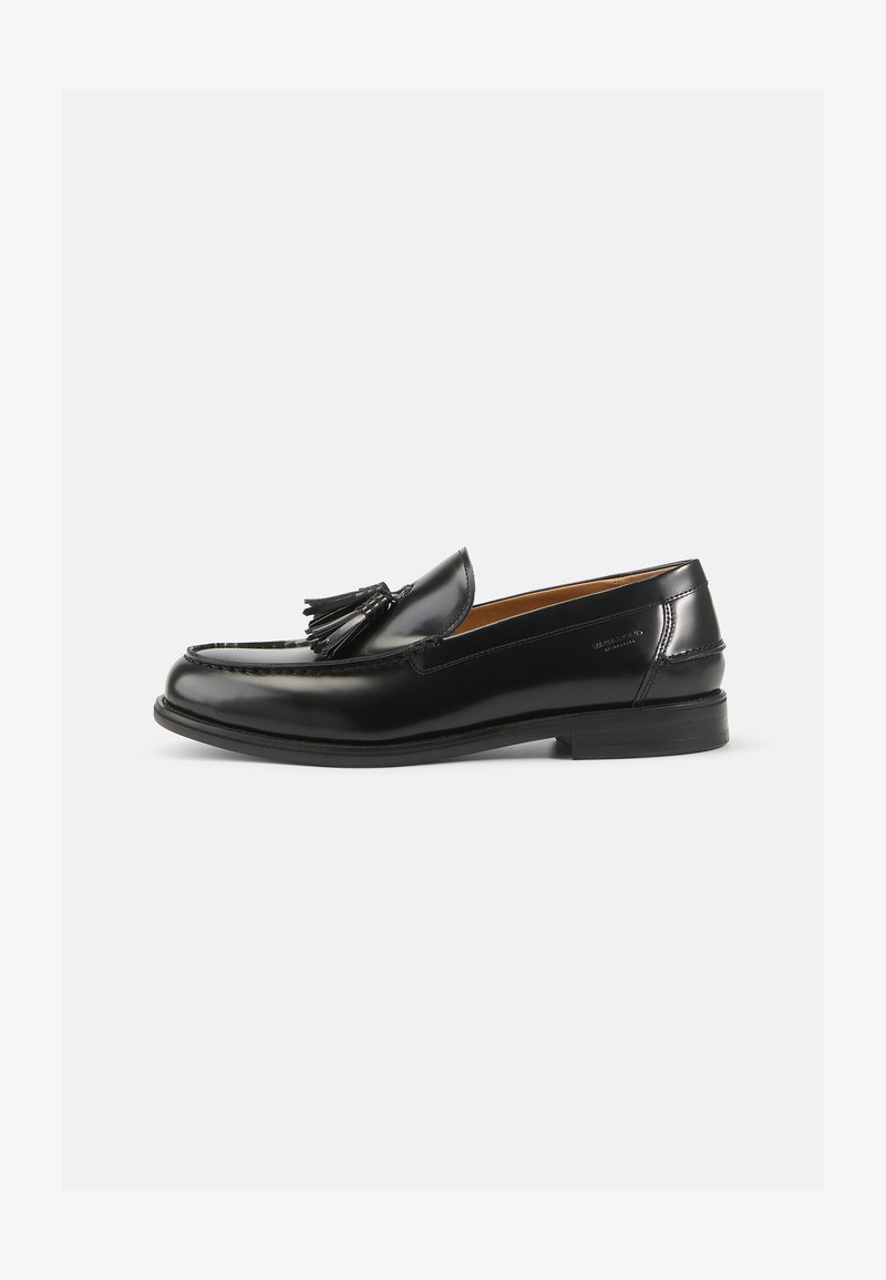 Schwarze Leder Slipper mit einem Quastenakzent, runder Spitze und glatter Oberfläche. Die Sohle ist flach mit minimalem Profil.