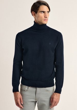 Jersey de cuello vuelto en color azul marino, confeccionado en una tela de punto fina, con mangas largas y una silueta ajustada, que presenta un sutil detalle del logotipo en el pecho.