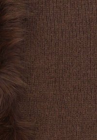 Tessuto marrone lavorato a maglia con un morbido bordo in pelliccia marrone soffice lungo un lato. La texture è a coste con un motivo uniforme su tutta la superficie.