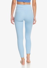 Lichtblauwe legging met een zachte, rekbare textuur en hoge tailleband, ontworpen voor comfort en een snug fit. Geschikt voor sportkleding.