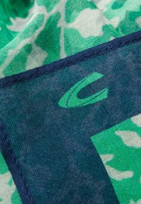 Zielono-niebieski szal w wzory o teksturowanym splocie, z ciemnoniebieskim wykończeniem i detalem logo w jasnoniebieskim kolorze.