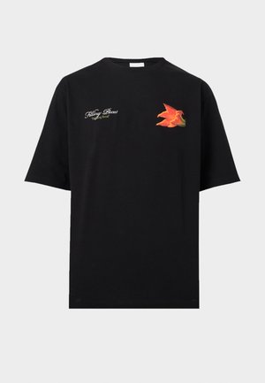 Black short-sleeve t-shirt with white cursive text "Filling Pieces" and a vibrant orange flower graphic on the chest.