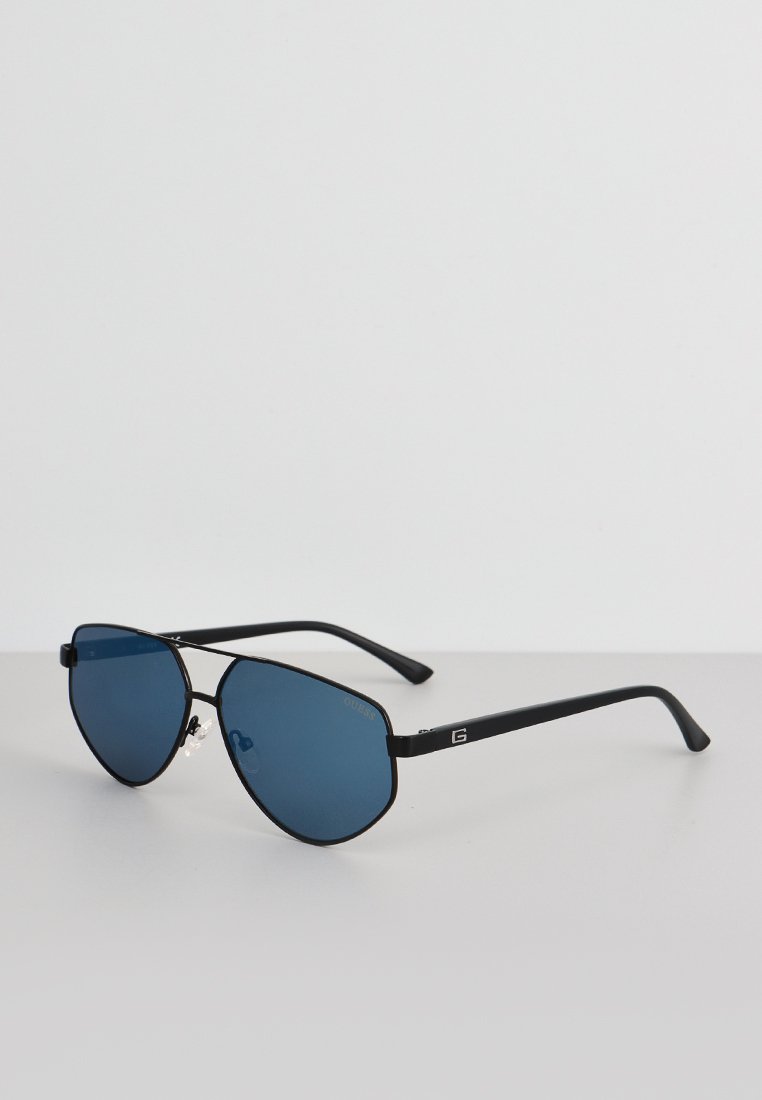 Occhiali da sole aviatori con montatura in metallo nero e lenti blu. Le caratteristiche includono punte appuntite, naselli regolabili e logo sulla stecca.