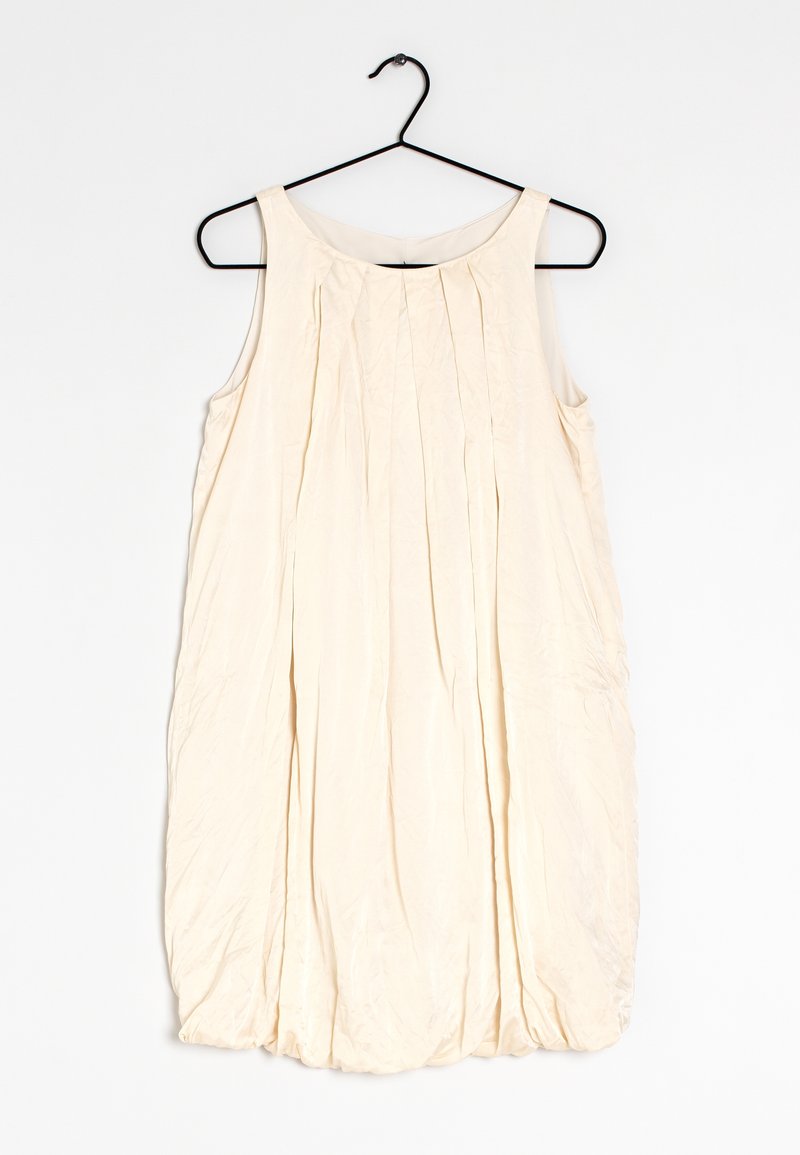 Pale beige sleeveless dress with subtle pleats, rounded neckline, and a flowing silhouette, made from a lightweight, textured fabric.