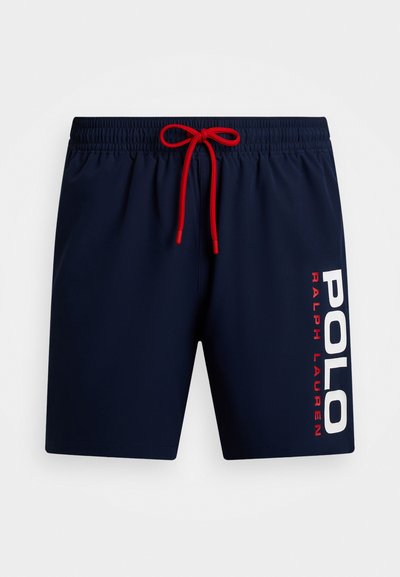 Navy krāsas peldbikses ar sarkanu auklu, elastīgu jostu un baltu "POLO RALPH LAUREN" tekstu, kas vertikāli izdrukāts pa kreiso pusi.