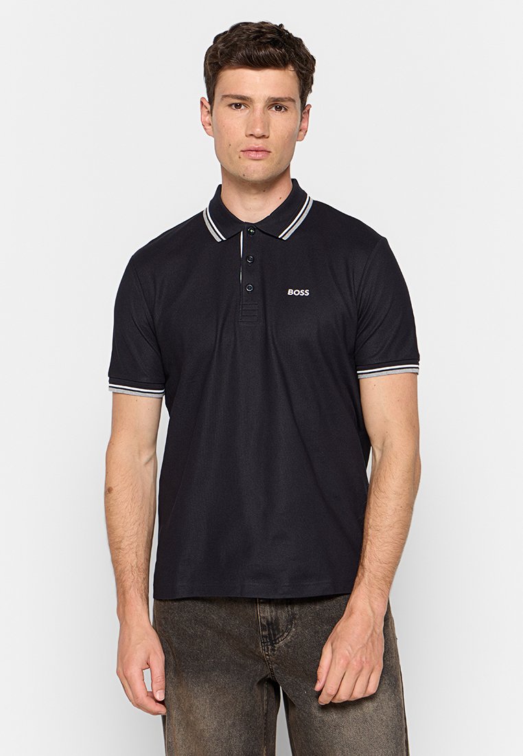 Schwarzes Poloshirt mit einer Drei-Knopf-Leiste, kontrastierenden weißen und bunten Streifen am Kragen und an den Ärmelbündchen sowie einem kleinen "BOSS"-Logo auf der Brust.