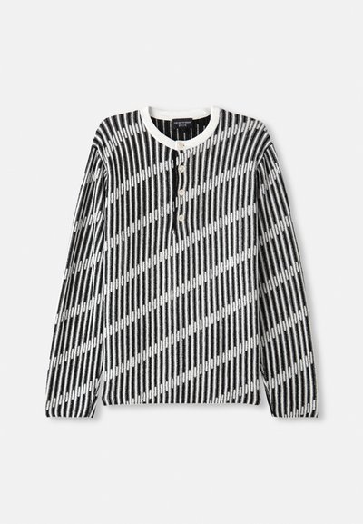 Sweater de manga longa em preto e branco com padrão de riscas diagonais, apresentando um decote redondo e quatro botões à frente. Tecido texturizado.