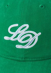 Zöld sapka textúrált anyagból, fehér hímzett "LD" logóval. A sapka klasszikus formájú, hajlított árnyékkal és varrási részletekkel rendelkezik.