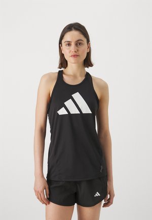 Débardeur de sport noir en tissu lisse, avec un grand logo Adidas blanc au centre. Le design comporte des bretelles fines et un col rond.