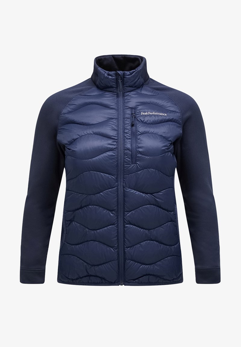 Giacca blu navy con frontale imbottito trapuntato a motivo ondulato, maniche in tessuto morbido, colletto alto e tasca sul petto con zip.