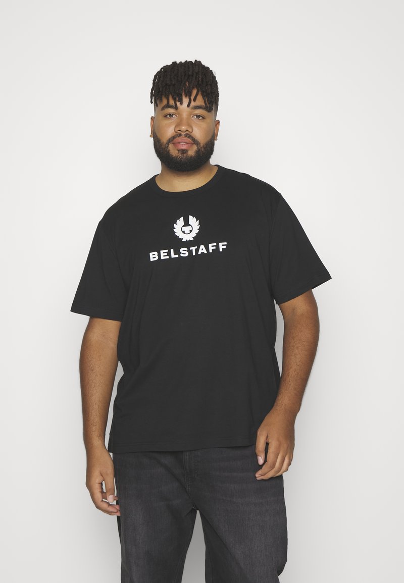 Juodas medvilninis marškinėliai su balta "BELSTAFF" logotipu ir emblemą centre. Trumpi rankoviai ir laisvas siluetas. Derinami su tamsiomis džinsais.