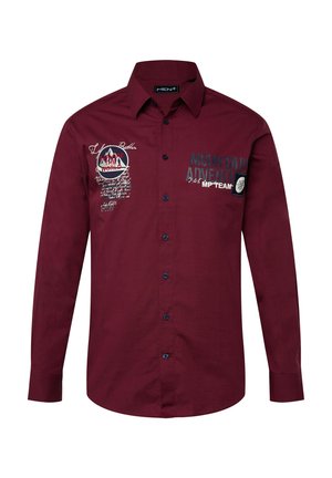 Burgundy pitkähihaisessa paidassa, jossa on siniset napit ja brodeerattuja vuori- ja tekstityksiä edessä.