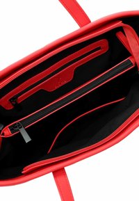 Borsa tote sintetica rossa con una texture liscia, interno nero, tasche con zip e aperte per l'organizzazione, e un design minimalista.