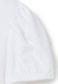 Blusa de algodón blanca con mangas abullonadas, textura suave y escote redondeado con un dobladillo limpio a lo largo de la sisa.
