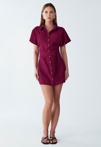 Bordoo värvi vööl särk-kleit, lühikeste varrukatega, nööbiga ees, kahe rinna taskuga ja struktureeritud siluetiga.