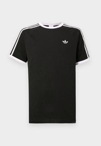 Čierne tričko vyrobené z bavlny s bielymi akcentmi. Má krátke rukávy, raglánový strih a malé logo na hrudi. Tri biele pruhy na pleciach.