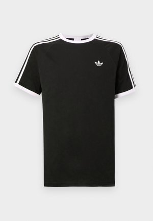 T-shirt nera in cotone con dettagli bianchi. Presenta maniche corte, design raglan e un piccolo logo sul petto. Tre strisce bianche sulle spalle.