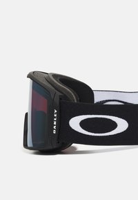 Zwarte skibril met een donkere lens, schuimrubberen padding en een brede elastische band met een opvallend wit logo.