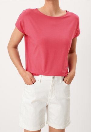 Kortærmet, rundhalset lyserød top kombineret med hvide shorts, med opbukket kant og frontlommer. Blød tekstur i stoffet er tydelig.