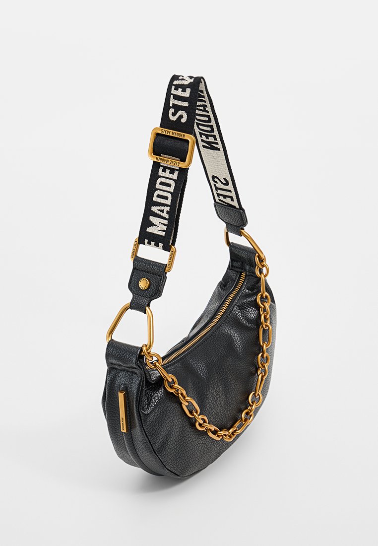 Bolso de hombro de cuero negro con un diseño curvado, acentos de cadena dorada y una correa en contraste negra y crema con texto.