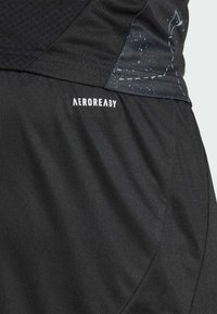 Shorts deportivos negros con la marca AEROREADY. Tejido texturizado con un acabado suave, realzado por un sutil patrón estrellado en el lateral.