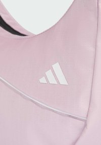 Reggiseno sportivo rosa chiaro con tessuto testurizzato, cuciture bianche a contrasto e un grande logo Adidas bianco sul davanti.