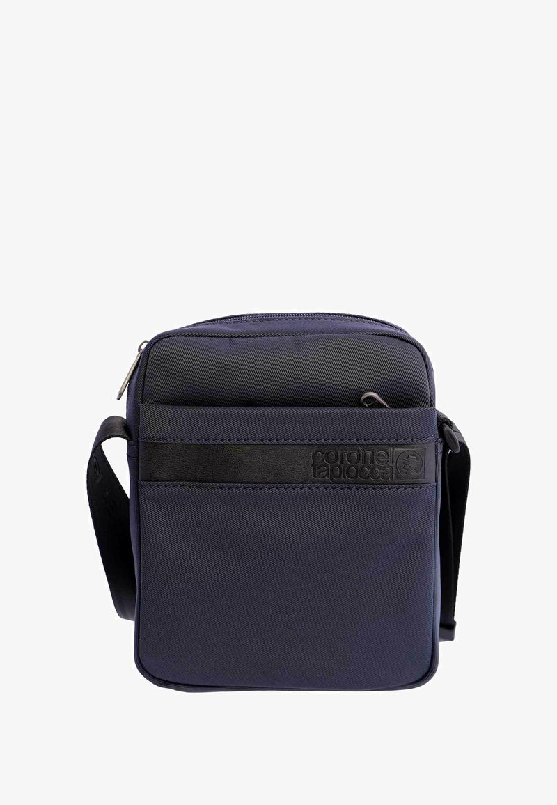 Bolso cruzado compacto en azul marino con correa negra y bolsillo delantero con cremallera, que presenta una tira con el logotipo en relieve "coronel tapiocca".