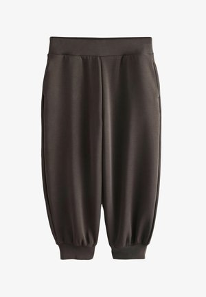 Laisalt istuvad tumedad hallid dressipüksid, millel on elastne vöökoht ja soonikkätised, küljetaskud ning sile kangapind.