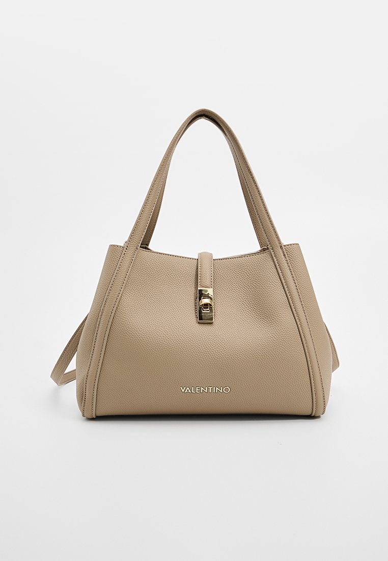 Beige leren handtas met een gestructureerde vorm, voorzien van een goudkleurige sluiting, handvatten aan de bovenkant, en een logo in reliëf aan de voorkant.