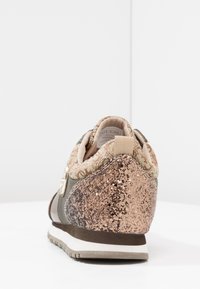 Sneaker in einer beigen und bronzenen Farbpalette, mit strukturiertem Material, dekorativen Glitzerdetails und einer gepolsterten Sohle.